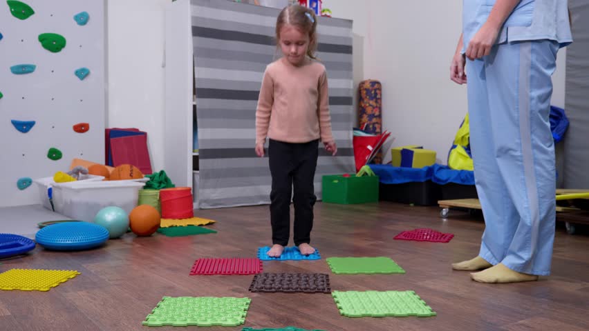 Kid on Sensory Mat Massage during sensory integration session. child girl in rehabilitation centre with physiotherapist doing orthopedic correction.  Royalty-Free Stock Footage #1101336587