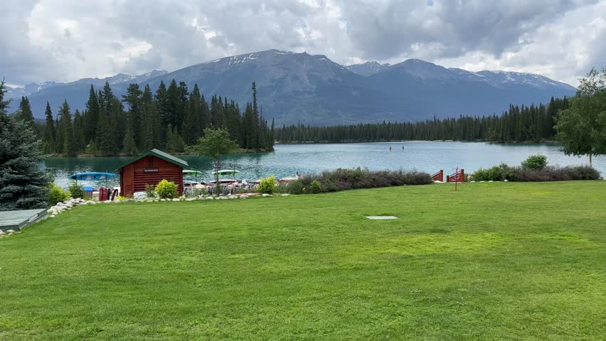 View of Beauvert Lake at Jasper, Alberta,Canada in a summer. The pristine alpine lake is surrounded by forest with mountain peaks in the distance. 