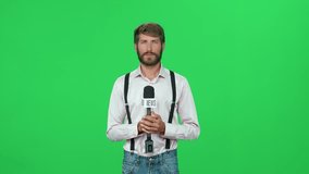 News, man reporter looks into the camera and speaks into a microphone, studio TV news shooting, chroma key template.