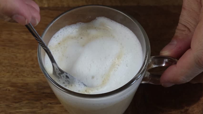 coffee with milk mixed with a spoon