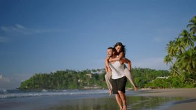 Boyfriend carrying girlfriend on his back, having fun at the seaside on the summer day. Happy cheerful laughing couple on the beach fooling around and biggybacking. Young woman riding her man's back - Powered by Shutterstock - Get 15% off with code: PIKWIZARD15