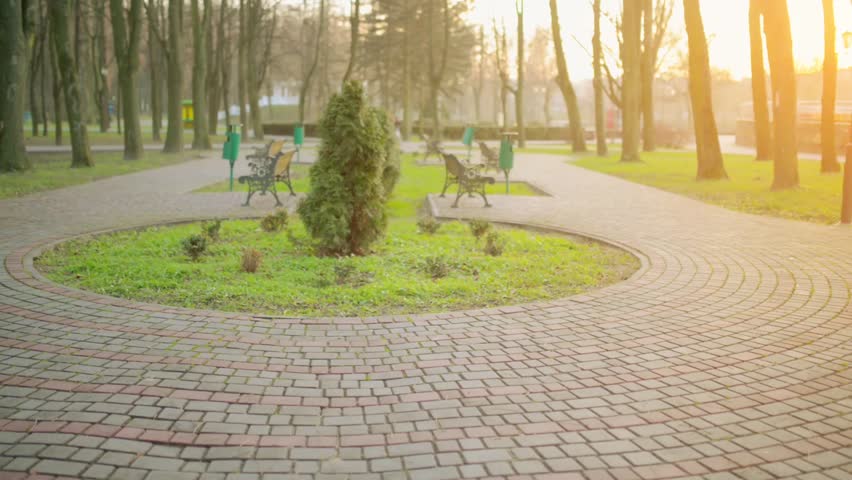 Mom teaches with her daughter to ride bicycle in autumn city park.