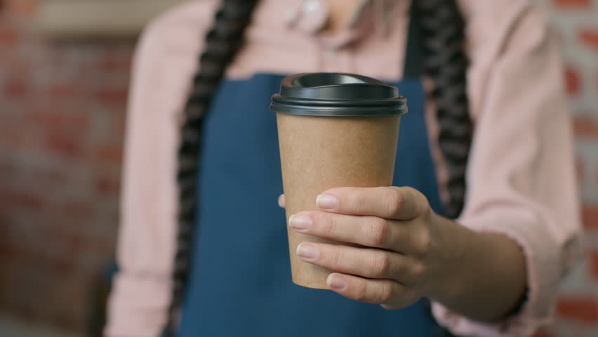 Close-up unrecognizable woman barista waitress in apron holding disposable paper cup with hot coffee or tea female small business owner cafe restaurant coffee house serving drink takeaway food concept Royalty-Free Stock Footage #1101358273