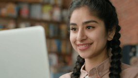 Close-up smiling young indian woman looking at laptop screen indoors checking email browsing social network hispanic girl student studying online remote chatting on internet typing message on computer - Powered by Shutterstock - Get 15% off with code: PIKWIZARD15