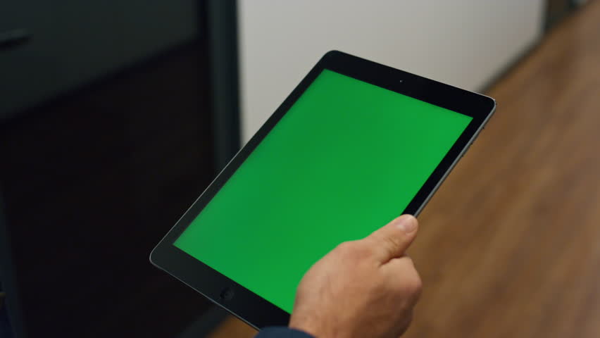 Businessman hands hold tablet with chroma key screen closeup. Man watch online conference reading company research in office. Unrecognized worker manager walking check email on green digital computer