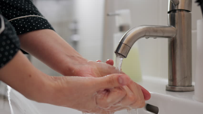 By washing her hands thoroughly under a stream of warm water and soap, a young woman eliminates any germs or bacteria that may be present, ensuring her hands are clean and hygienic
 | Shutterstock HD Video #1101362289