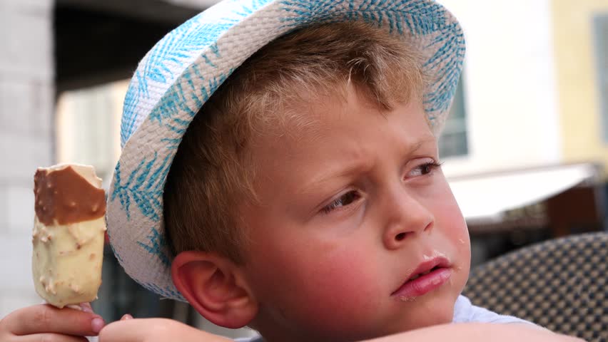 young boy with summer hat eating an icecream