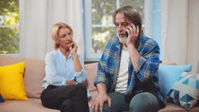 Mature woman watch husband getting excited news on phone call. Middle-aged couple receive good news from doctor over phone and hug. Happy senior husband and wife celebrate success. Realtime - Powered by Shutterstock - Get 15% off with code: PIKWIZARD15