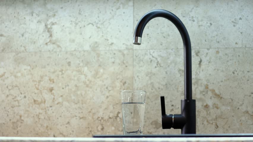 A man's hand turns on the faucet in the kitchen, a man draws a glass of water. Drinking tap water, filtration. | Shutterstock HD Video #1101366655