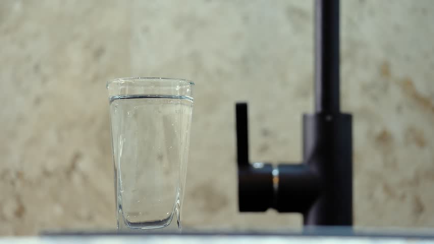 Clean drinking water from the tap. Slow motion. A glass of water, a beautiful frame. Concept: thirst, saving resources, water use, utility prices, flushing money down the drain. | Shutterstock HD Video #1101366659
