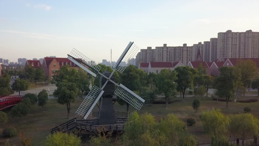 Aerial orbits old Dutch windmill in Suzhou city, replica Tower Bridge