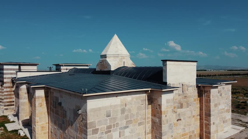 An accommodation structure built during the Seljuk State. It was made of cut stone and was restored in the following years. The camera flies over the cone into the countryside.