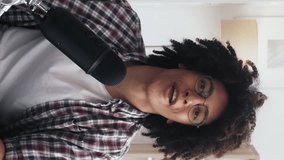 Vertical video. Podcast recording. Interview stream. Enthusiastic excited smart influencer guy in glasses waving hello speaking into microphone. - Powered by Shutterstock - Get 15% off with code: PIKWIZARD15