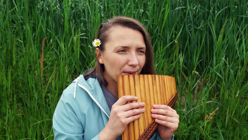 A young woman plays the panflute in nature Royalty-Free Stock Footage #1101388191