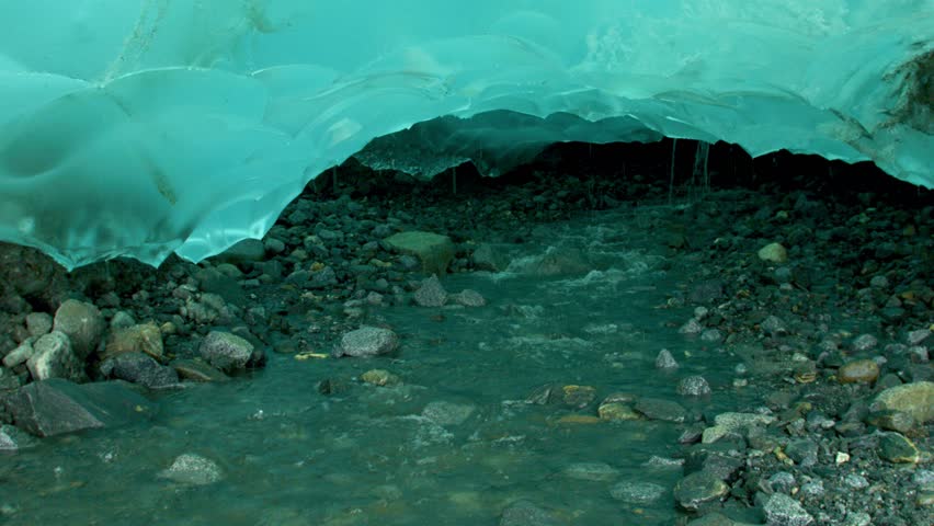 The ice under the rocks gradually melts and forms rivers. Turquoise ice. Exploring the Hidden Wonders of Alaska