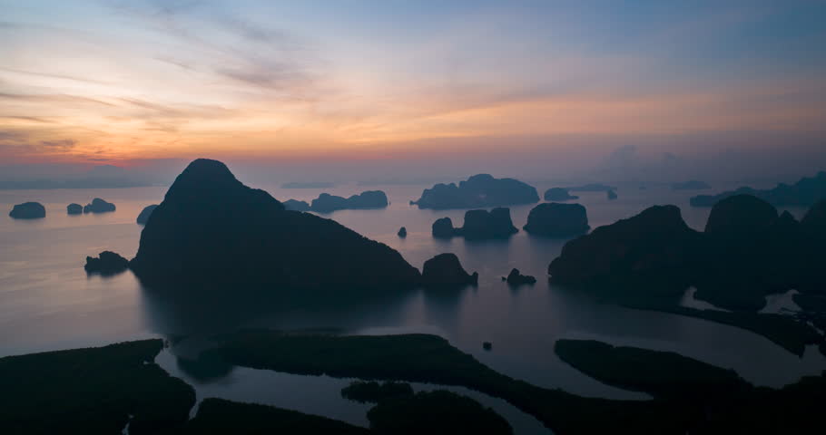 Aerial view of Phang Nga bay with mountains at morning sunrise in Krabi, Thailand. Landscape of Amazing red sky with dramatic sea at magic moment. Fantastic natural Drone time-lapse over the Bay. Royalty-Free Stock Footage #1101392603