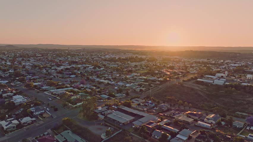 Early morning sunrise high angle aerial drone footage of the historic outback mining town of Broken Hill, New South Wales, Australia. Flying over residential and business districts. Shot in 60 fps. 
