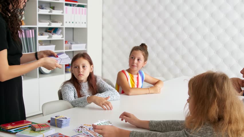 Woman English Teacher The kids are playing a game. Learning in small groups. Children learn. Classes after school. English Language Club