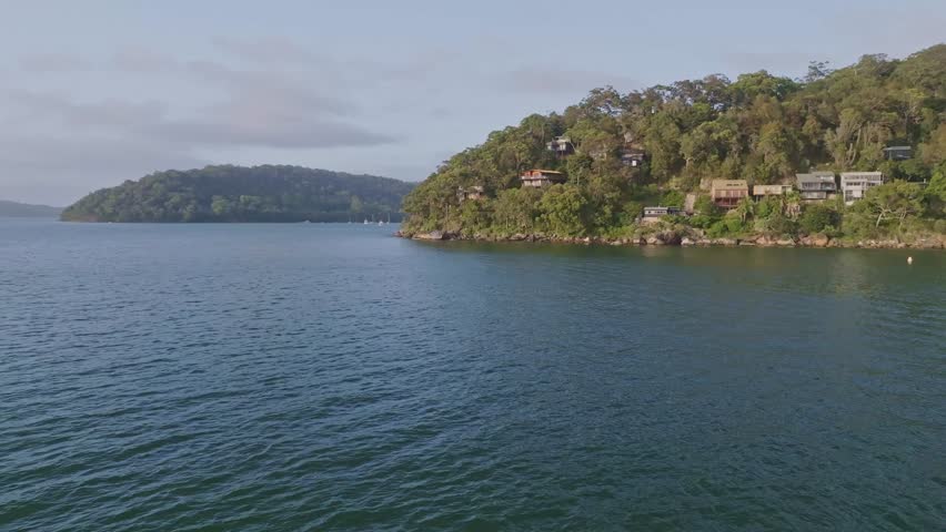 Drone view of holiday homes at Sinclair Point with Currawong Beach behind near Great Mackerel Beach on the western shores of Pittwater in Ku-ring-gai Chase National Park, Sydney, NSW, Australia.