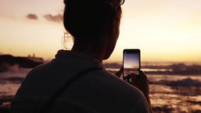 Woman Sitting Outdoors at Sea Beach Holding Mobile Phone to Make Picture. Hipster Girl at Summertime Break on Coastline Side Taking Footage for Social Media. Female in Ocean Wind of Seashore Nature 4k - Powered by Shutterstock - Get 15% off with code: PIKWIZARD15