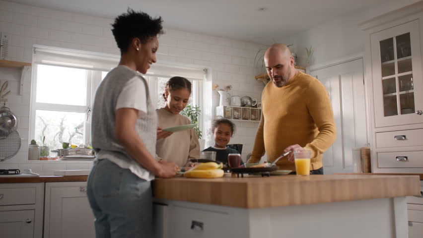 Family and boy with Down syndrome making pancakes for breakfast Royalty-Free Stock Footage #1101404031