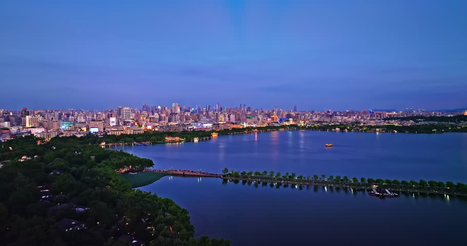 Aerial view of West Lake natural scenery and city skyline in Hangzhou at night, China.
