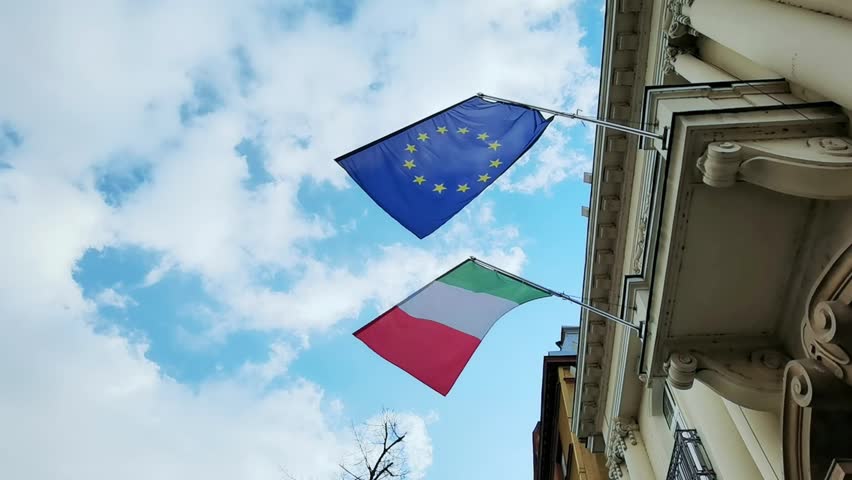 Italy and Euro. National country flag on blue sky background. Flying fabric symbol. Tourism or travel summer day. international patriotic emblem. Nobody. Horizontal video