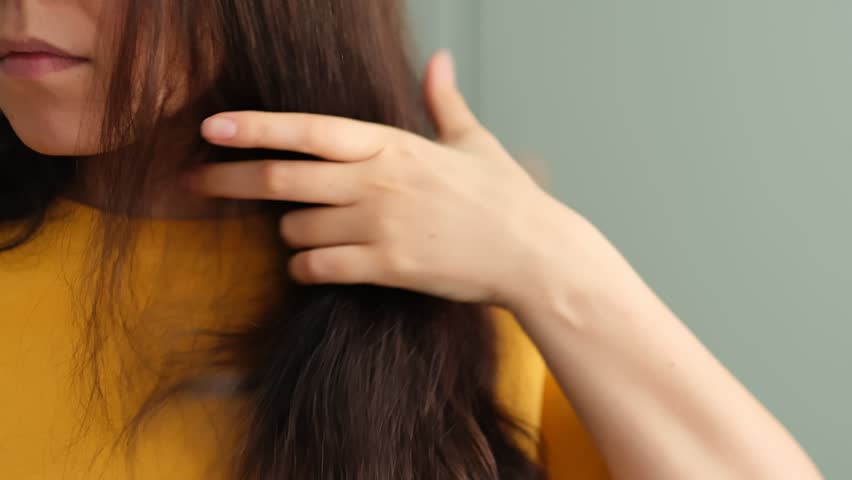 frustrations of a brunette woman dealing with dry and tangled hair, showing the importance of proper hair care and the challenges many people face in maintaining healthy locks. Royalty-Free Stock Footage #1101408205