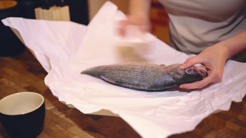 Girl cooking fish in the kitchen