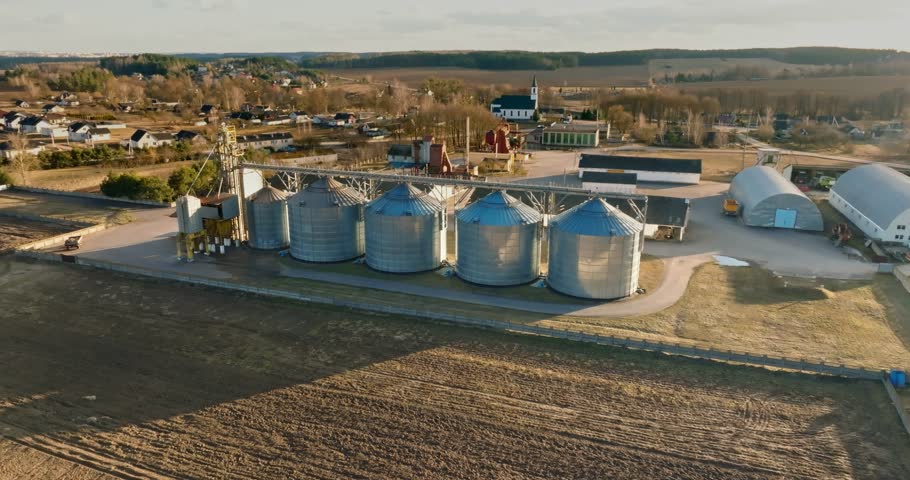 circular flight and aerial view over agro silos granary elevator on agro-processing manufacturing plant for processing drying cleaning and storage of agricultural products, flour, cereals and grain.  Royalty-Free Stock Footage #1101418041