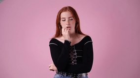 4k video of girl with thoughtful facial expression on pink background.