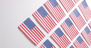 Vertical video of multiple national flags of usa lying with copy space on white background. Patriotism, celebration and national flags.