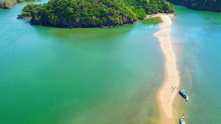 The shallow waters surrounding the sandbank are often calm and clear, making them ideal for swimming, snorkeling, or other water-based activities. (Dragon Spine Beach, Satun Province, Thailand). 4K
