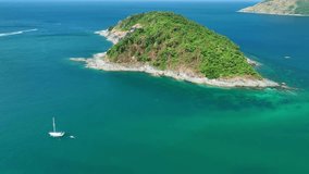 Small island at andaman sea.Sea waves and beautiful water surface High quality video Bird's eye view,Aerial view drone tracking boat sailing boat in beautiful phuket sea
