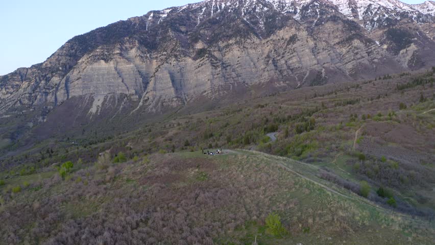 Wasatch mountain and s-quaw peak road reveal behind friends relaxing by fire