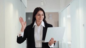 Smart intellectual woman is having a remote interview via a video call on her laptop with the webcam on, discussing education in the office lobby. Online conversation is seamless and engaging. - Powered by Shutterstock - Get 15% off with code: PIKWIZARD15