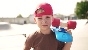 child boy with skateboard. boy in a red cap with a skateboard on the playground portrait. skateboarder child close-up lifestyle outdoors sun glare. kid skateboarder looking at the camera - Powered by Shutterstock - Get 15% off with code: PIKWIZARD15