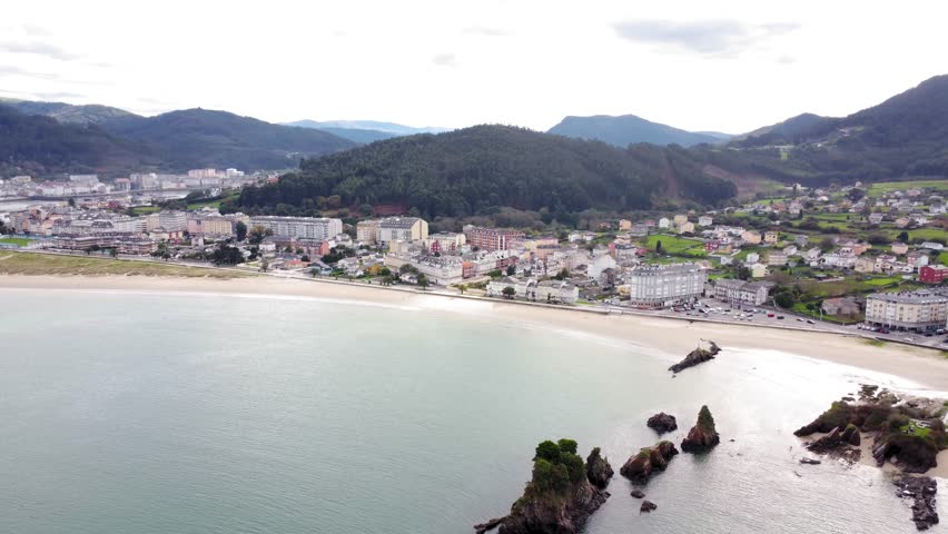 Panoramic aerial view of beautiful country side of Galicia - Spain. View of Covas city, in background is the city of Viveiro. Beautiful landscape with green fields and mountains. Drone forward
