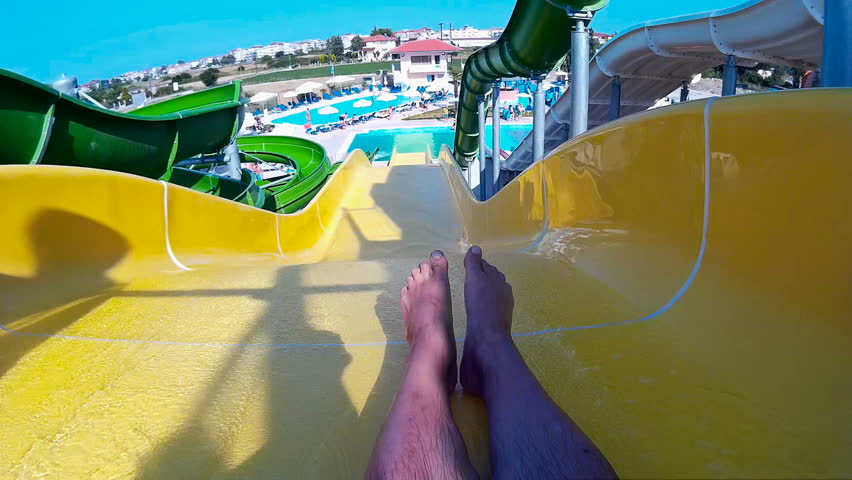 Going down the water slide in aqua park ; Young man coming down the waterslide in aqua park,video clip