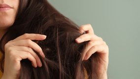 common problem of dry, tangled hair with this video of a distressed brunette woman examining her locks. hair treatments, conditioners, and products designed to restore hair's health and manageability.