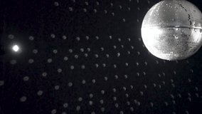 A spinning mirrored disco ball reflects light onto the wall. - Powered by Shutterstock - Get 15% off with code: PIKWIZARD15