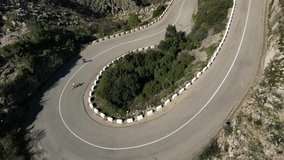 Aerial footage of a cyclist riding up the Vall de Ebo pass.Man cyclist  wearing cycling kit and helmet is training.Cycling in the spanish mountains.Sport motivation video.Pego,Alicante.