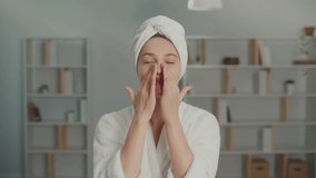 Portrait of a Smiling Young Woman Applying Moisturizing Cream on Her Face. A Happy Woman with a White Towel on Her Head Cares About Her Skin at Home. Concept of Skincare, Cosmetics, Healthcare. - Powered by Shutterstock - Get 15% off with code: PIKWIZARD15