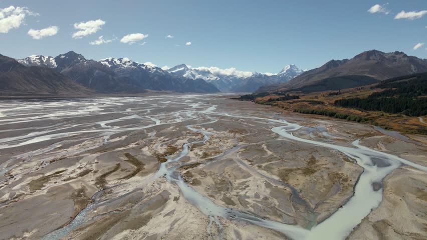 Braided Tasman river in vast alpine valley in front of Mount Cook; aerial establishing shot