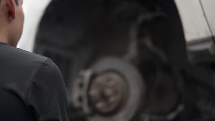 Slow motion shot of a mechanic checking a car's brakes and rotors Royalty-Free Stock Footage #1101448071