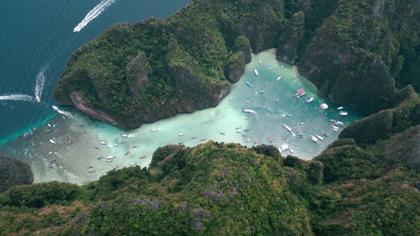 Top view aerial shot of Scenic Pileh Lagoon filled with boats with turquoise sea water, limestone cliffs with green vegetation. Long-tailed boats and many tourists. Pileh Bay, Krabi, Thailand | Shutterstock HD Video #1101450469