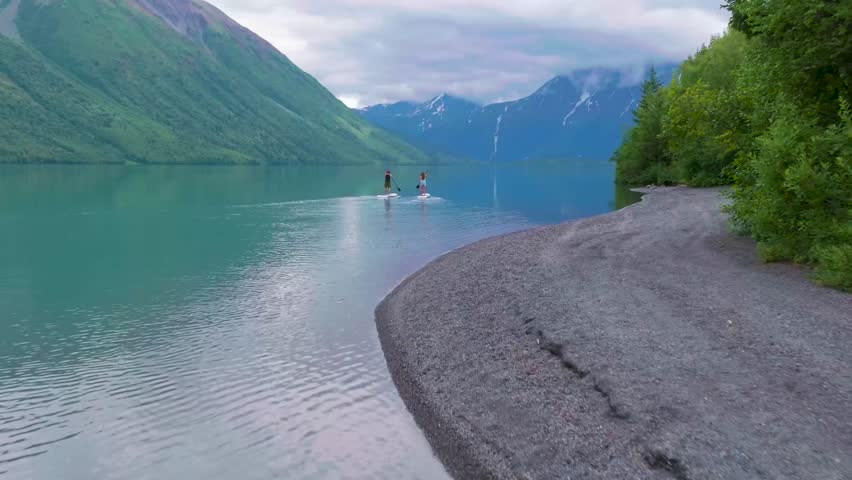 A couple paddle boarding on Kenai Lake in Alaska.