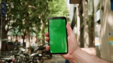 Green Screen chroma key Handheld Smartphone phone with Barcelona city view, Spain, Travel with phone concept, application mock up. City street in europe. Adlı Stok Video