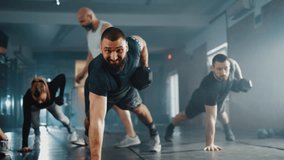 Personal trainer controls a group of people performing Renegade Row using dumbbells in planking position during intense workout at gym. - Powered by Shutterstock - Get 15% off with code: PIKWIZARD15