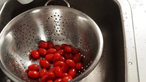 Wash tomatoes under running water. Tomatoes in splashes of water. close-up.